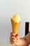 Yellow ice cream in a waffle cone in a child\'s hand