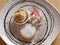 Yellow icecream with white cream and strawberry in white plate closeup.