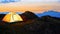 Yellow Illuminated Tent in the Beautirul Evening Mountains. Adventure and Travel.