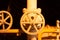 Yellow industrial pipeline with valves close-up on dark background. Pipeline equipment, fuel plant industry.