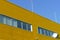 Yellow industrial steel facade under blue sky perspective view