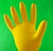 Yellow inflated rubber glove for cleaning on a blue background.