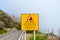 Yellow information sign warning of rockfall danger in Portuguese and English language. The usage of the road is under exclusive