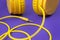 Yellow jack plug cable and headphones on purple background. Music concept.