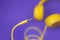 Yellow jack plug cable and headphones on purple background. Music concept.