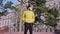 In a yellow jacket a guy standing in front of the camera in the middle of the empty street in quarantine he wearing the