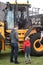 Yellow JCB tractor being viewed by a family