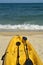 Yellow kayak and black paddles on beach in tropical Baja, Mexico