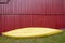 Yellow kayak over a red wooden cabin facade. Adventure sports