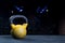 Yellow kettlebell with black handle on black floor with gym background and bokeh lights low key dark lighting with copy space