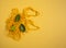 A yellow knitted string bag with green leaves lies on a yellow background. The concept of zero waste, replacement of