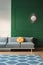 Yellow knot pillow on long grey couch in grey and green living room