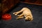 Yellow lab puppy laying on a slate kitchen floor, tired out after eating, red dog bowl