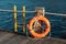 Yellow ladder and an orange lifebuoy with rope on the pier in th