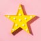 Yellow lamp as star with white LED lights on pink background. Creative concept. Top view. Flat lay style. Children`s modern night