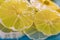 Yellow lemon. Transparent slices of lemon on a blue surface. Healthy vegetarian food. Macro, closeup, soft focus. Toned image.