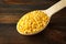 Yellow lentil in a wooden spoon