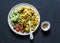 Yellow lentils, pumpkin, roasted turmeric cauliflower and vegetables in one bowl - healthy vegetarian food on a dark background,