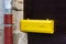 yellow letterbox on dark wooden door
