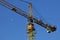Yellow lift crane with the moon in the background on blue bottom