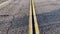 Yellow line of road markings on the road pavement, on the highway that crosses the desert in the Mojave from Los Angeles.
