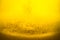 Yellow liquid honey texture close up with some solid particles in transparent jar