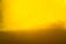 Yellow liquid honey texture close up with some solid particles in transparent jar