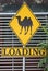 Yellow loading sign with the drawing of a camel on it