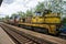 A yellow locomotive is standing at the station waiting to depart.