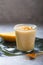 Yellow mango yogurt or smoothie on grey background. Turmeric Lassie or lassi in glass