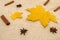 A yellow maple leaf lies on a beige jumper. Cinnamon sticks.