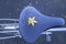 A yellow maple leave on frozen bicycle seat during Autumn