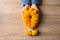 Yellow marigold flower garland in hand on wooden background