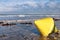 Yellow Marker Buoy at Low Tide on a Wet Sand Beach