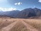 Yellow meadow with highway and mountains