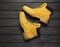 Yellow men`s work boots from natural nubuck leather on dark wooden background top view flat lay with copy space. Trendy casual
