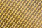 Yellow mesh structure in close-up with backlight on shine morning shows abstract pattern of seamless material textured in golden