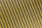 Yellow mesh structure in close-up with backlight on shine morning shows abstract pattern of seamless material textured in golden