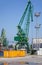 Yellow metal cargo container and green crane