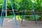 Yellow metal children`s swing on a sports playground in the park wrapped with red barrier tape