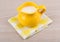 Yellow milk jug, napkin on wooden table