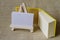 A yellow mini-notebook and a small wooden easel.