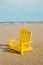 Yellow miniature chair on the beach