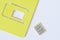 A yellow miniature nano-SIM card for a smartphone lies on a white background next to the package. Digital technologies and mobile