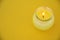 Yellow minimalistic centerpiece with a citronella candle in a glass. Empty copy space