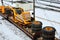 Yellow mining truck disassembled into parts, cab, body, electric motor, drive, wheels, loaded onto a cargo railway platform.