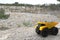 Yellow mining truck with stones at high mountain near quarry.