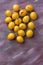 Yellow mirabelle plum fruits over painted textile background
