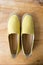 Yellow moccasin shoes on wooden table