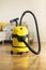 Yellow modern vacuum cleaner in living room. Copy space. Flat clean vacuuming concept